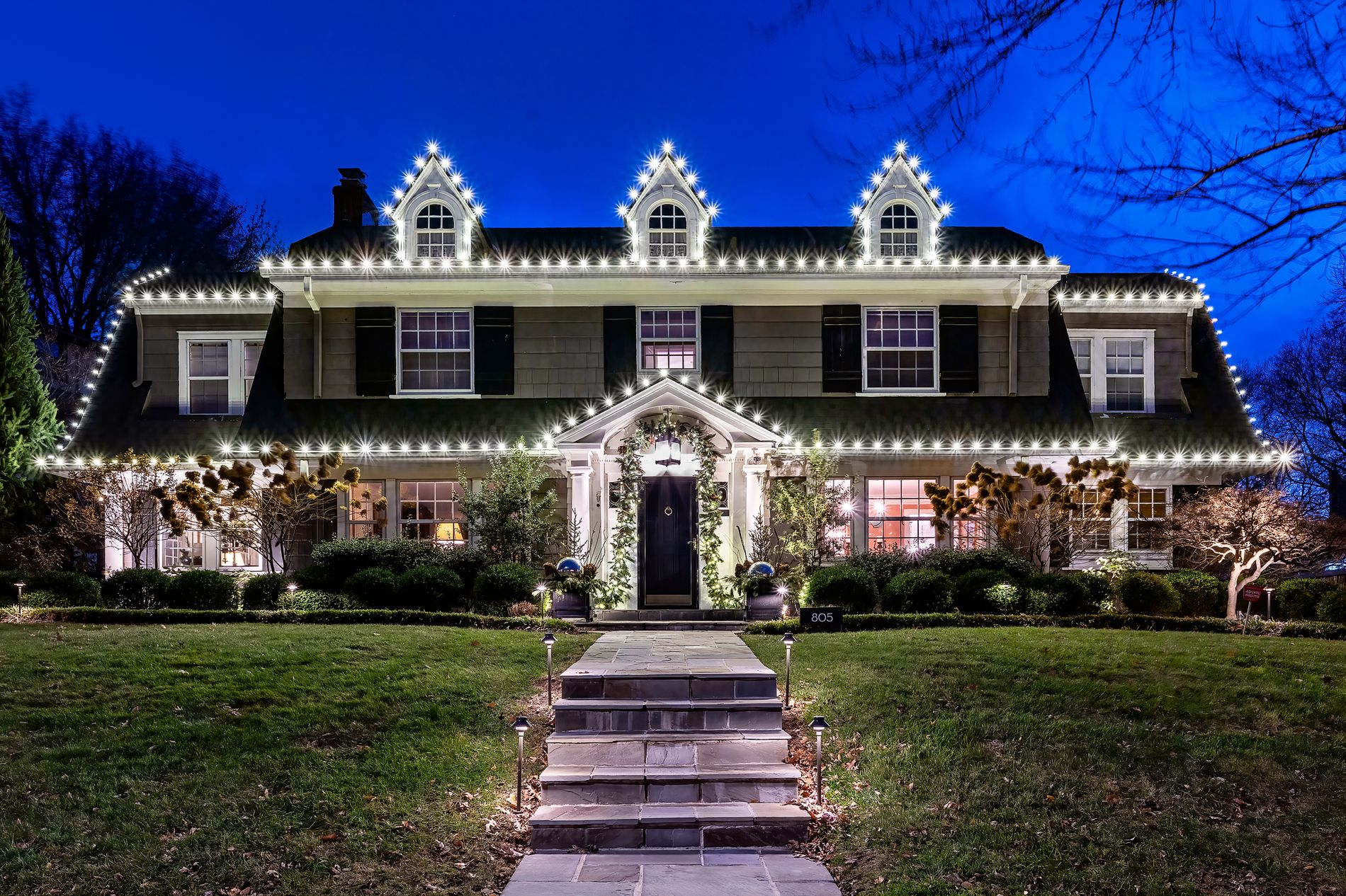 A Kansas City home lit for Christmas by Jingle Bros at dusk